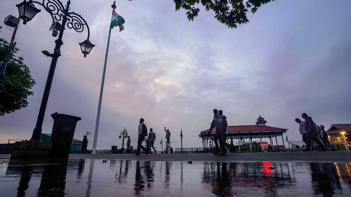 People take a stroll under the cloudy sky in Shimla.