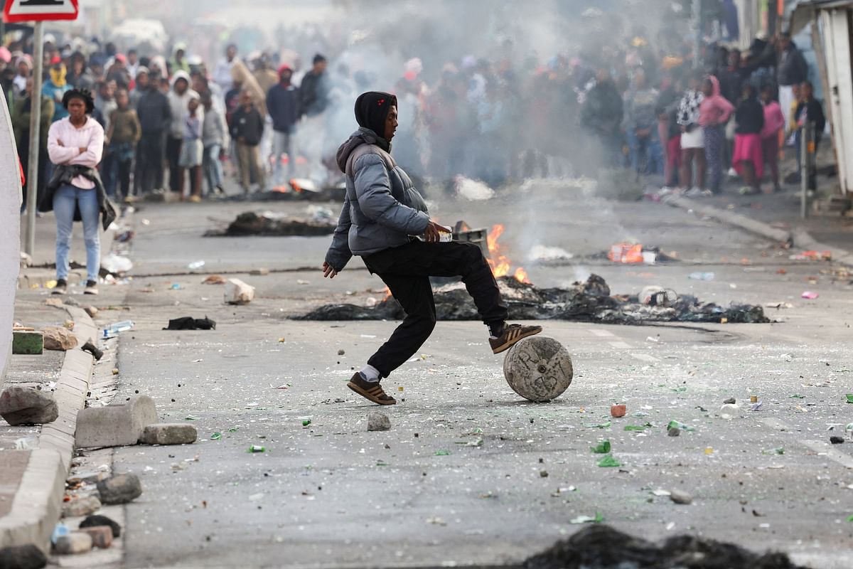A protester blocks the streets with stones and rubble during an ongoing strike by taxi operators against traffic authorities, in Msiphumelele, Cape Town, South Africa, August 8, 2023 REUTERS/Esa Alexander.