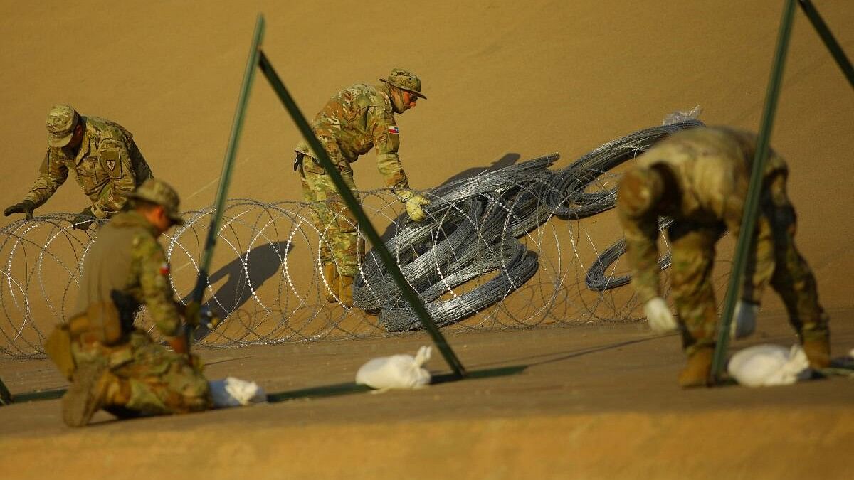 Members of the Texas National Guard place wire fence, as seen from Ciudad Juarez.