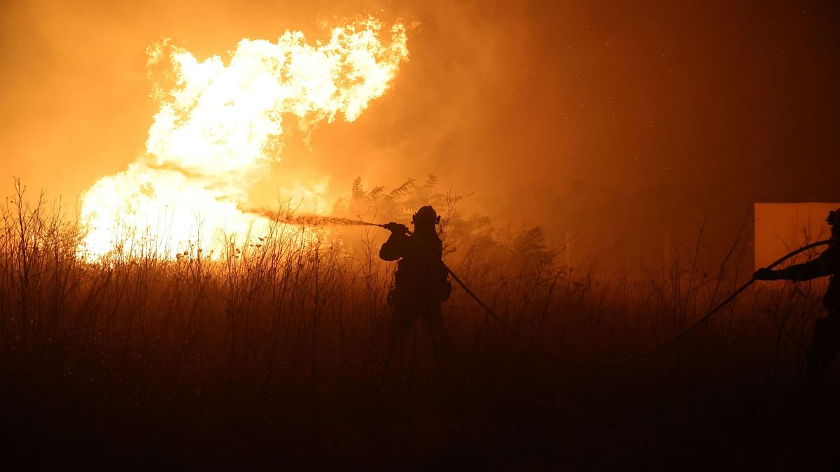 A firefighter tries to extinguish a wildfire burning near the village of Makri on the region of Evros, Greece, August 22, 2023.