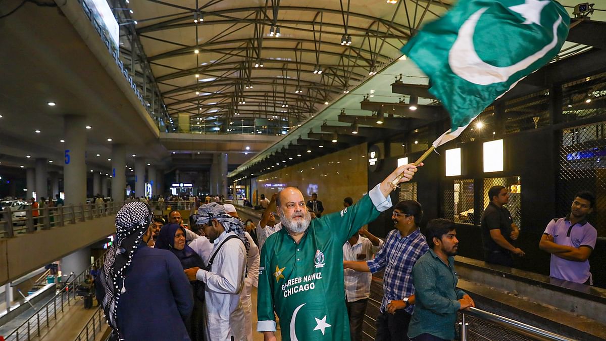A Pakistani fan waves the country's national flag during the arrival Pakistan team for ICC Cricket World Cup at Rajiv Gandhi International Airport, in Hyderabad, Wednesday, Sept. 27, 2023.