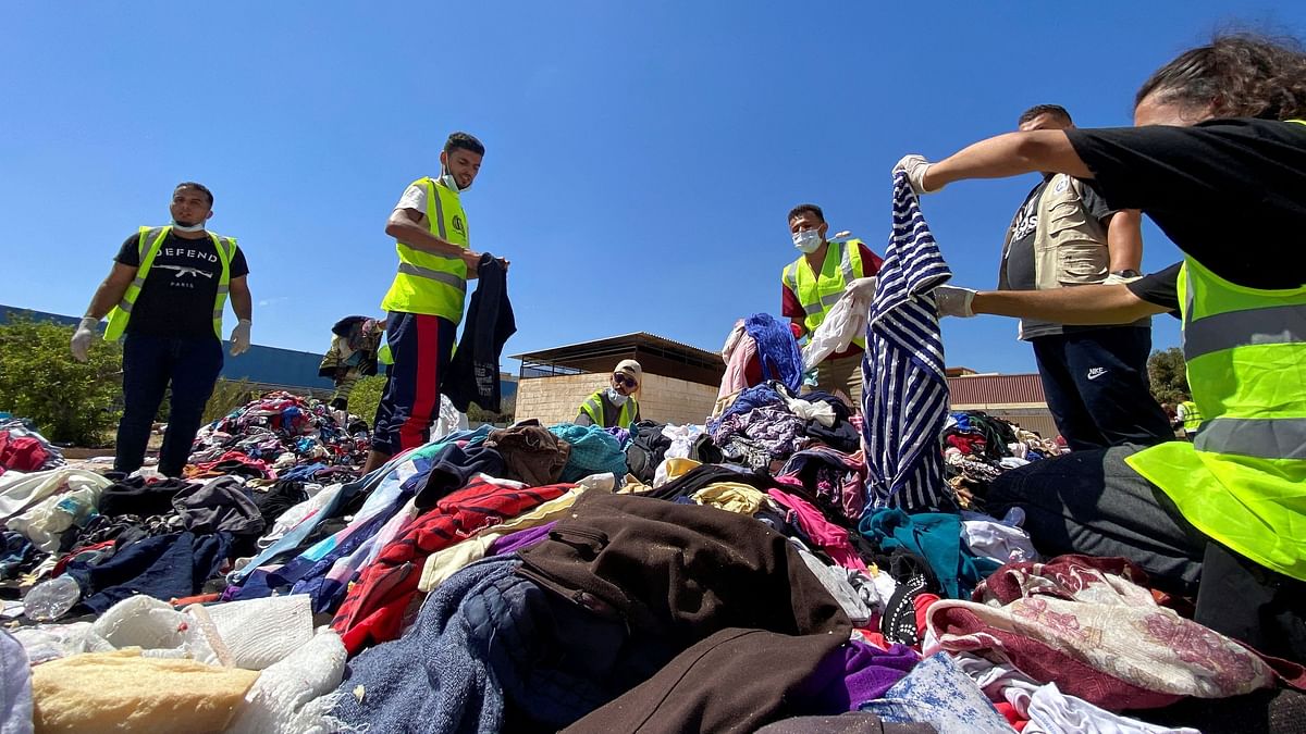 Volunteers from the Beltrees Youth Movement sort clothes that are to be distributed to the displaced people, in the aftermath of the floods in Derna, Libya.