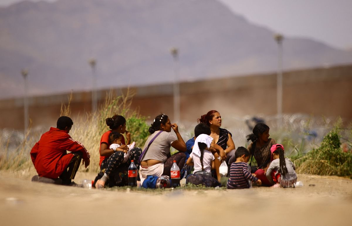Migrants from Venezuela, seeking asylum in the United States, sit before crossing the Rio Bravo river with the intention of turning themselves in to the U.S. Border Patrol agents, as seen from Ciudad Juarez, Mexico September 21, 2023.