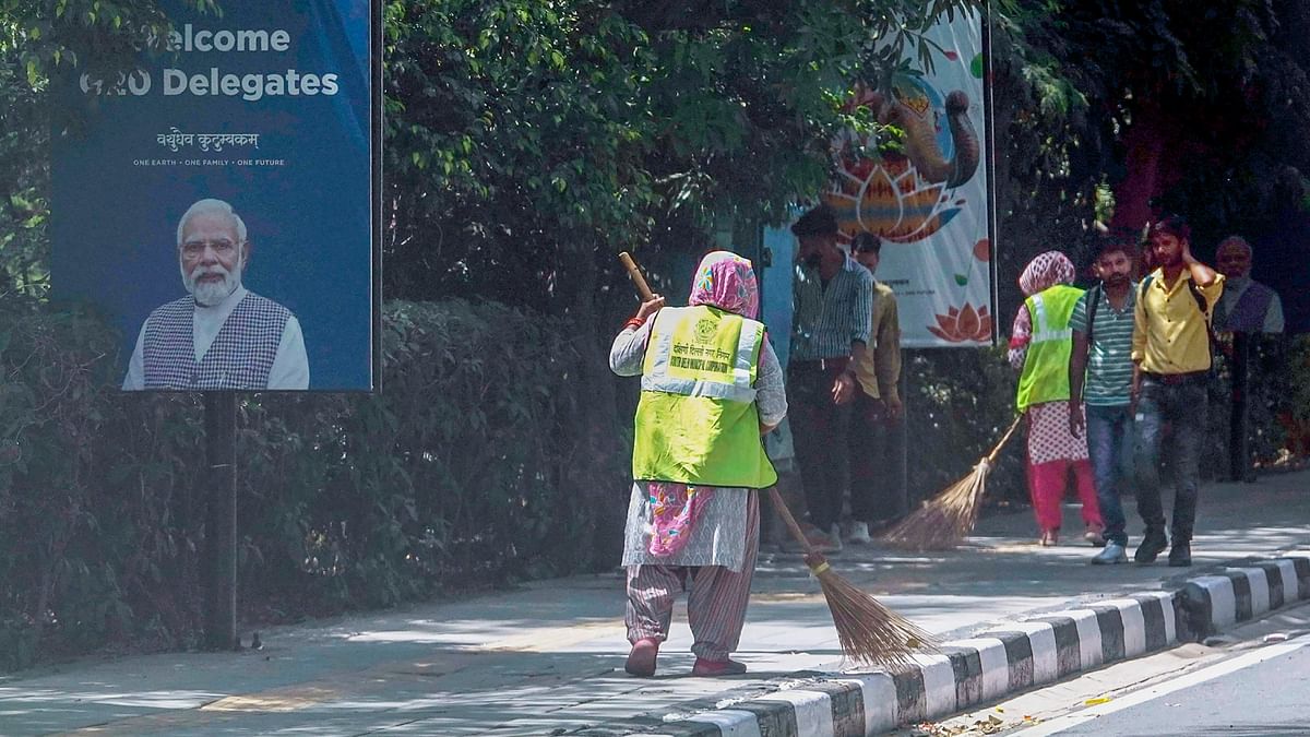 Workers clean a pavement near Rajghat in preparation for the upcoming G20 Summit, in New Delhi.