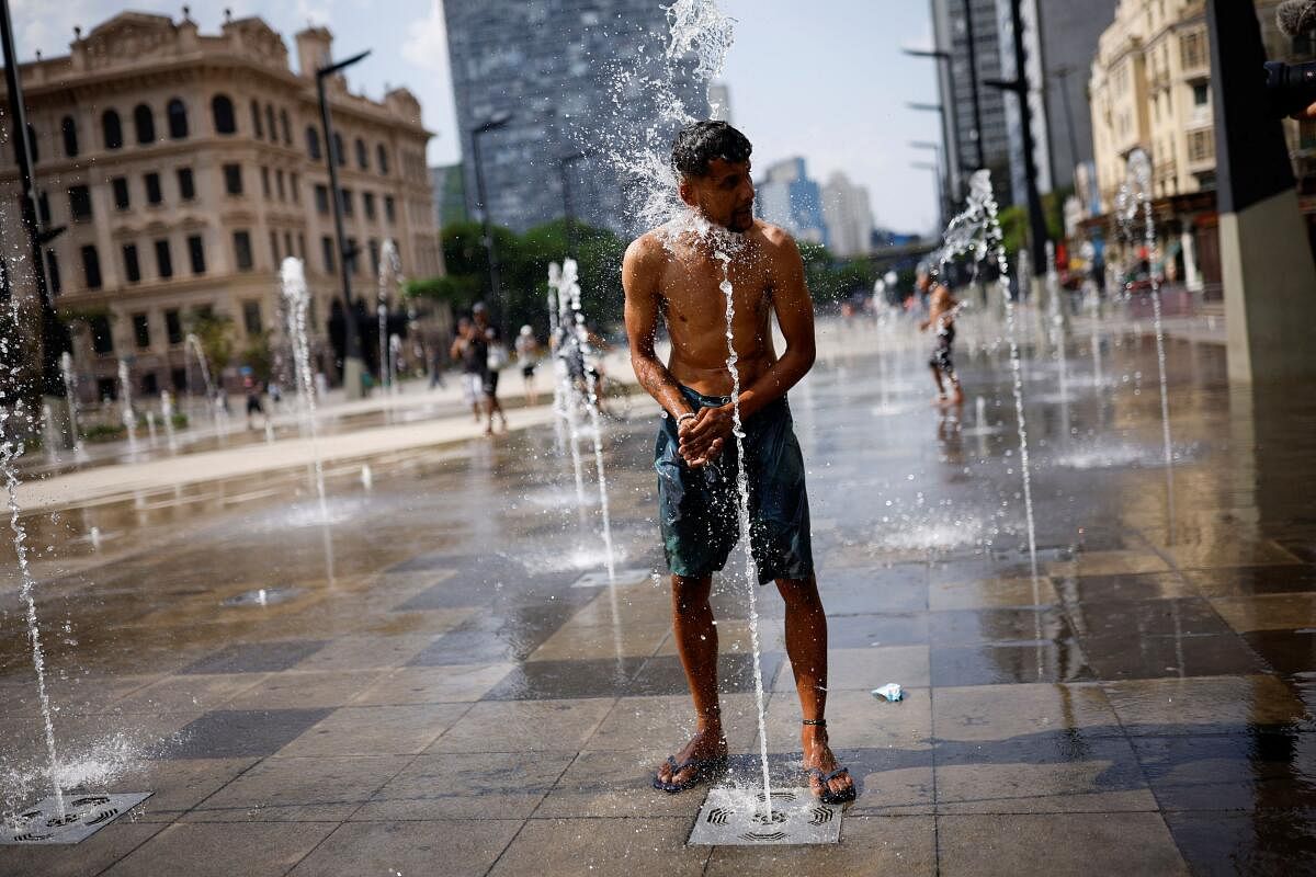 A man uses a fountain to cool off and wash himself, during a heatwave in the Anhangabau Valley, in the centre of Sao Paulo, Brazil.