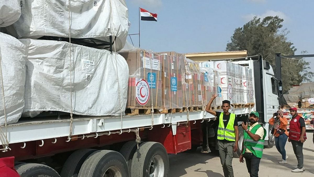 Egyptian Red Crescent members and volunteers gather next to a truck carrying humanitarian aid as it drives through the Rafah crossing from the Egyptian side, amid the ongoing conflict between Israel and the Palestinian Islamist group Hamas, in Rafah, Egypt October 22, 2023. 