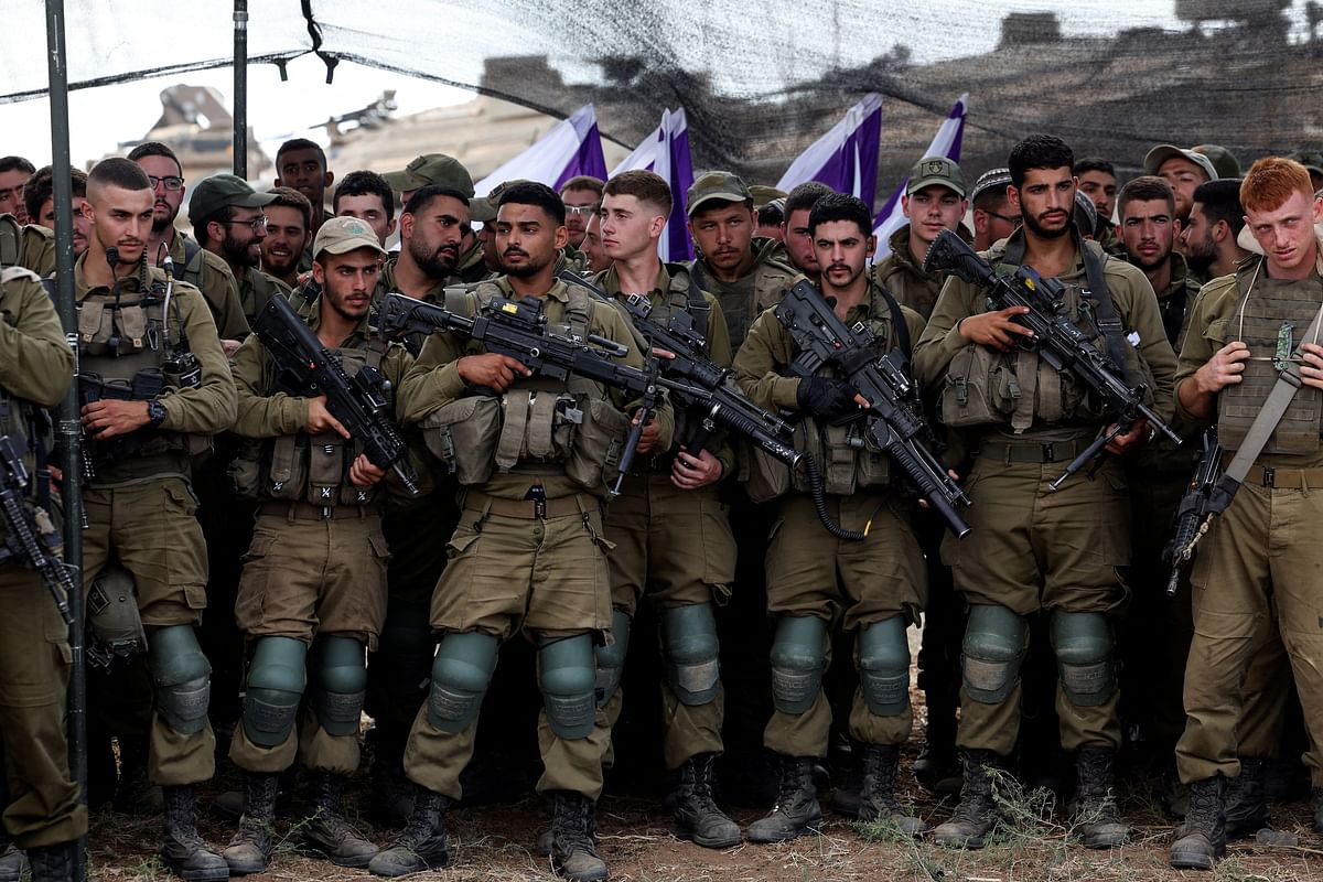 Israeli soldiers listen to Defence Minister Yoav Gallant as he meets them in a field near the country's border with the Gaza Strip, in southern Israel October 19,