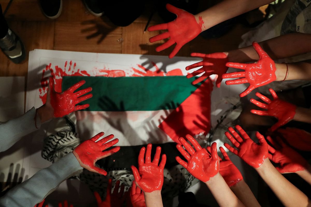 Members of the Palestinian community living in Chile show their hands painted in red as they attend a gathering, in Santiago, Chile.