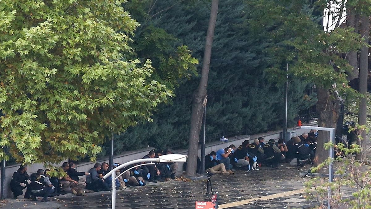 Members of the Turkish Police take cover as an unexploded bomb is detonated in front of the Interior Ministry following a bomb attack in Ankara, Turkey. 
