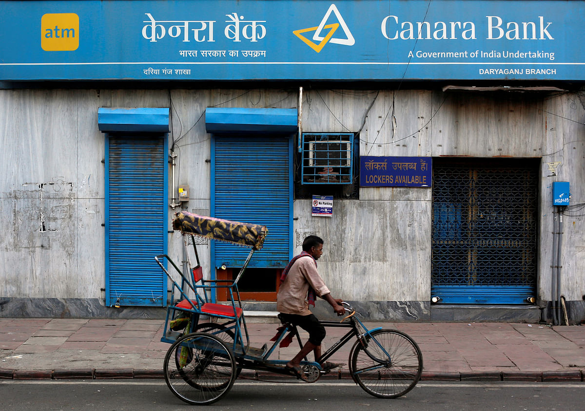 FILE PHOTO - A rickshaw puller passes the Canara Bank branch in the old quarters of Delhi India September 6 2017. REUTERS/Adnan Abidi/File Photo