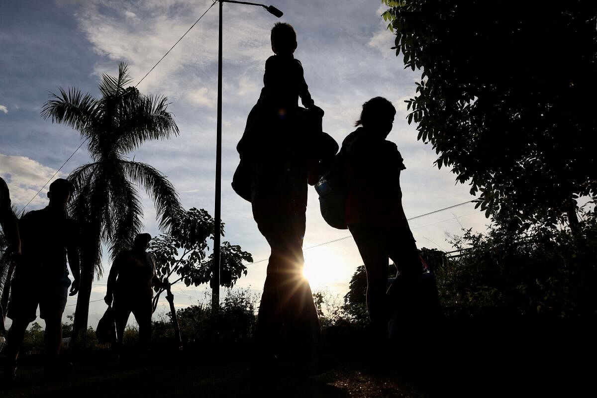 Migrants walk along the road in a caravan in an attempt to reach the U.S border, in Tapachula, Mexico. 