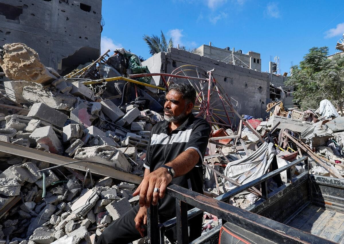 Hamdan stands on the rubble of his family home that was destroyed in the strike in Gaza. 