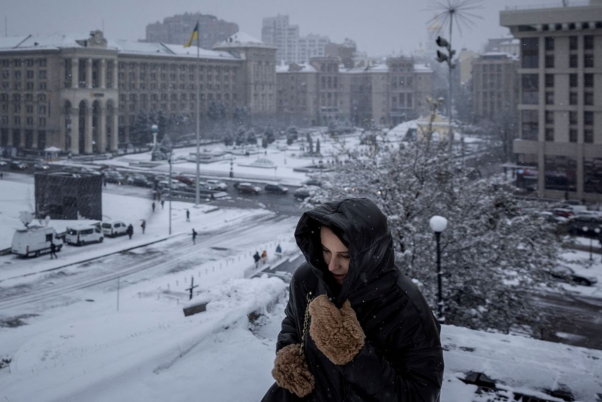 A woman walks near Independence Square  on the first snowy day of the year in Kyiv, amid Russia’s attack on Ukraine, November 22, 2023.  