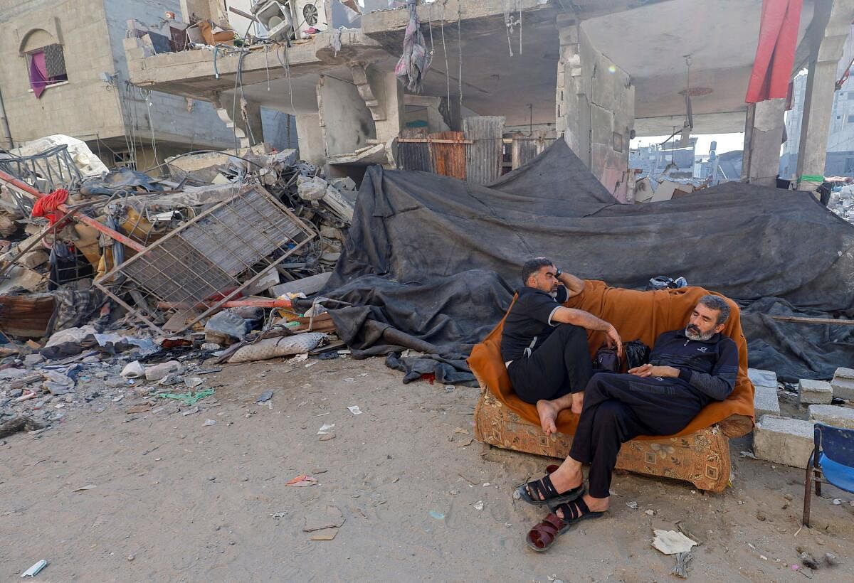 Hamdan rests on a couch near the rubble of his family home. 