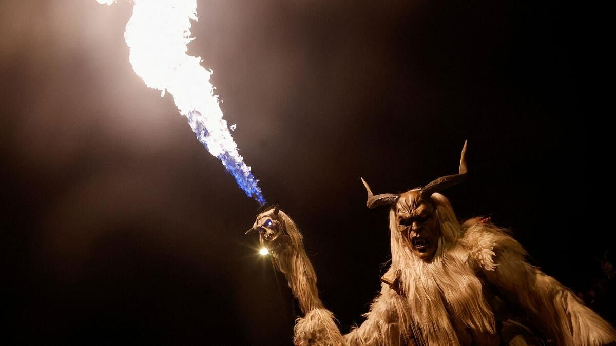 A person dressed as a horned evil spirit known as 'Krampus' parades with a torch through the small town of Goricane, Slovenia, November 18, 2023. 