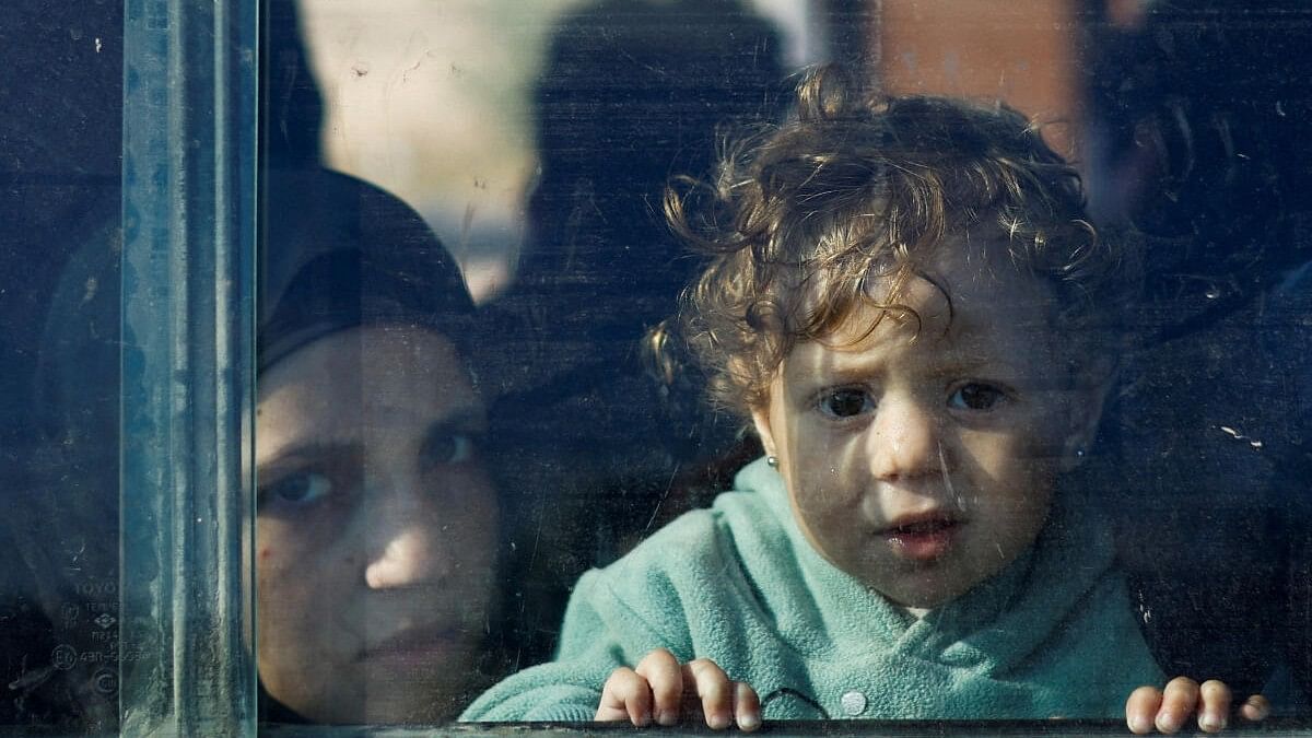 A Palestinian child looks out the window of a vehicle while fleeing north Gaza and moving southward, as Israeli tanks roll deeper into the enclave, amid the ongoing conflict between Israel and Hamas, in the central Gaza Strip November 18, 2023. 