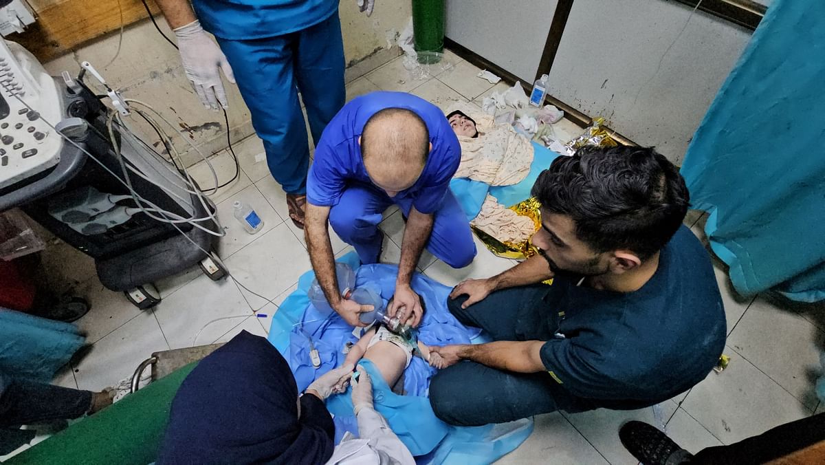 Medical workers use a manual resuscitator as they try to rescue Palestinian baby Mosab Sobieh, who is less than a year old and was injured in an Israeli strike on their home, as his injured mother lies next to him on the floor at the Indonesian Hospital that ran out of fuel and electricity, in the northern Gaza Strip, November 11, 2023. 
