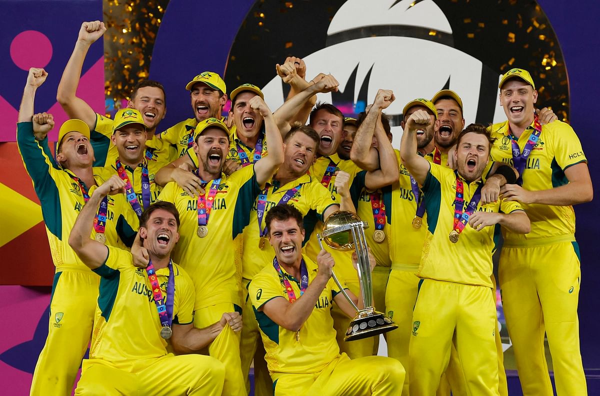   Australia's Pat Cummins celebrates with the trophy and teammates after winning the ICC Cricket World Cup.