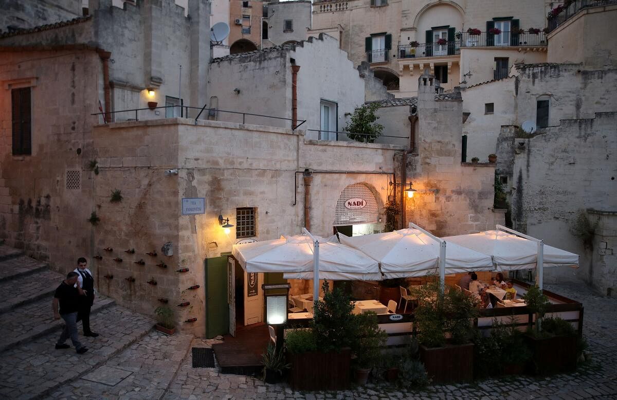 People enjoy the evening at a restaurant in Matera, Italy.
