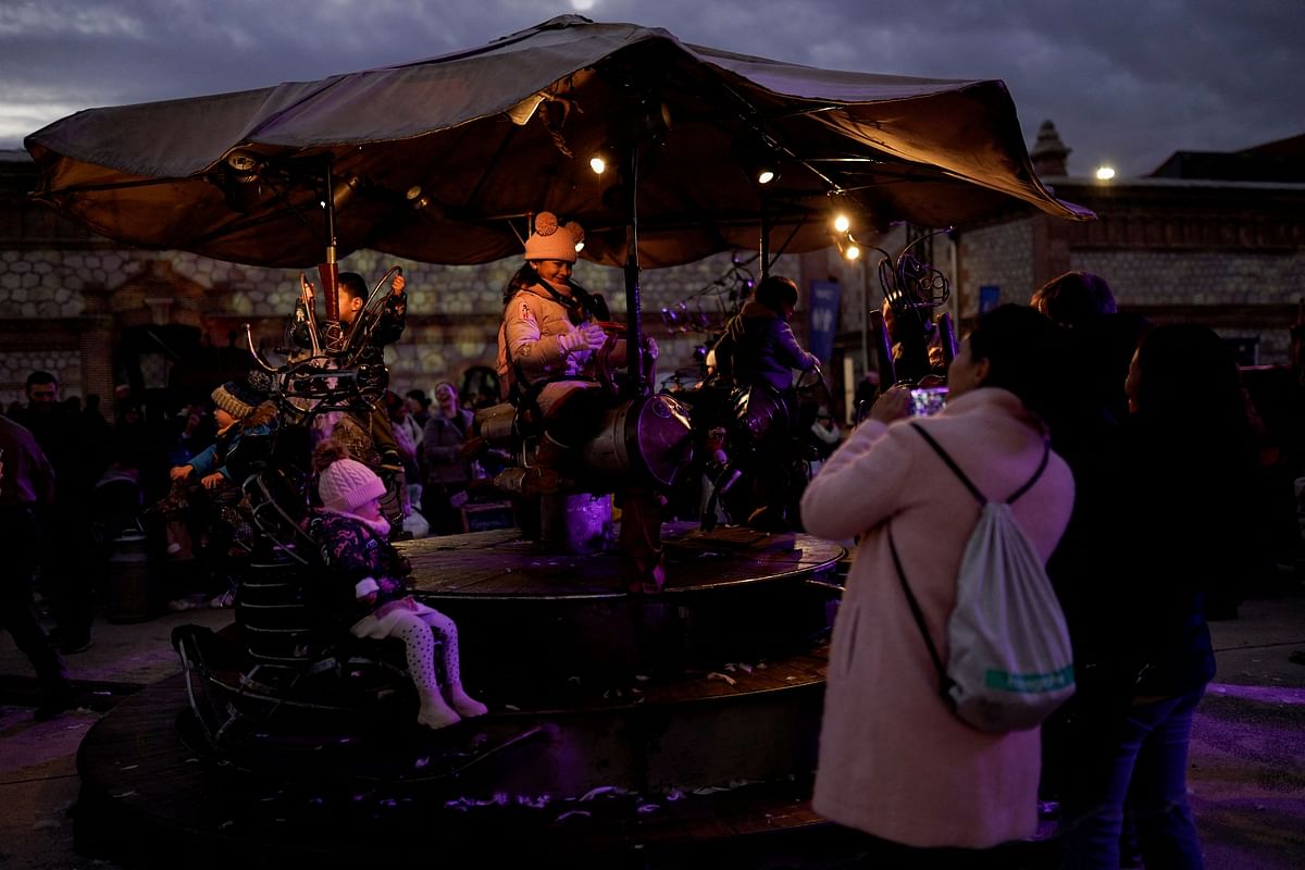 A woman takes a picture to the carousel installed in the Christmas market at Matadero Madrid culture centre in Madrid, Spain, December 30, 2023. REUTERS/Ana Beltran NO RESALES. NO ARCHIVES