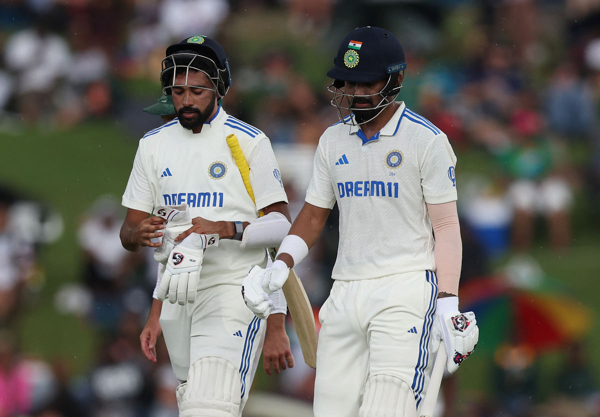  India's KL Rahul and Mohammed Siraj walk off the field as rain stops play