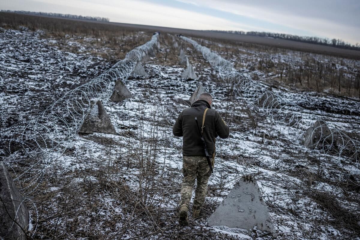 A Ukrainian serviceman walks along a part of defence structures near a front line, amid Russia's attack on Ukraine, in the Kharkiv Region, Ukraine December 25, 2023. 