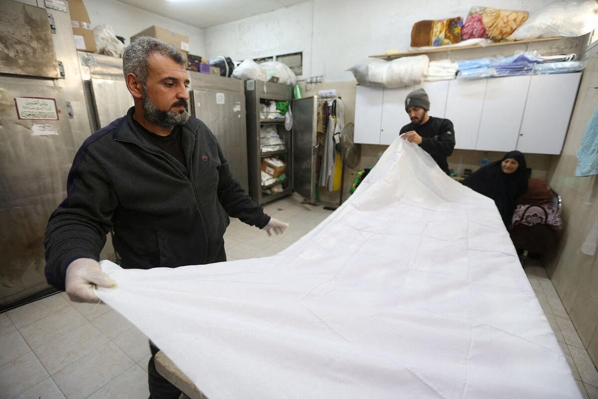 Mohammed Abu Mussa, a volunteer at Keratan society which prepares dead bodies for burial, prepares a white shroud, amid the ongoing conflict between Israel and the Palestinian Islamist group Hamas, at a hospital in Rafah, southern Gaza Strip, December 28, 2023. 