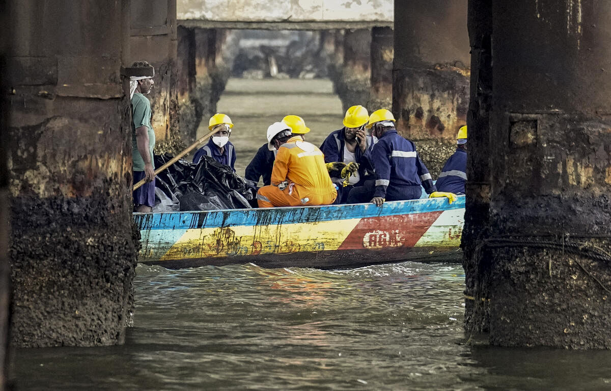 Rescue officials conduct an operation after an oil spill in the Bay of Bengal off the Ennore Creek area in the aftermath of Cyclone Michaung, in Chennai.