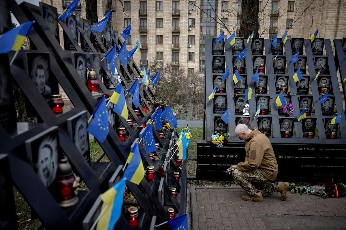 A soldier pays his respects at the monument to the so-called "Heavenly Hundred", the people killed during the Ukrainian pro-European Union (EU) mass demonstrations in 2014, during an event marking the tenth anniversary of the start of the uprising, amid Russia's attack on Ukraine, in Kyiv, Ukraine November 21, 2023. 