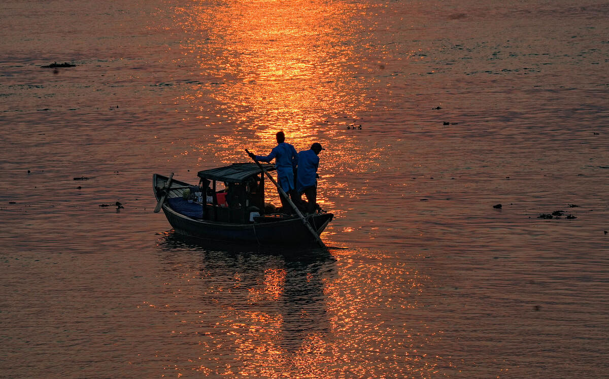 A boat silhouetted against the setting sun on the River Ganga in Kolkata.