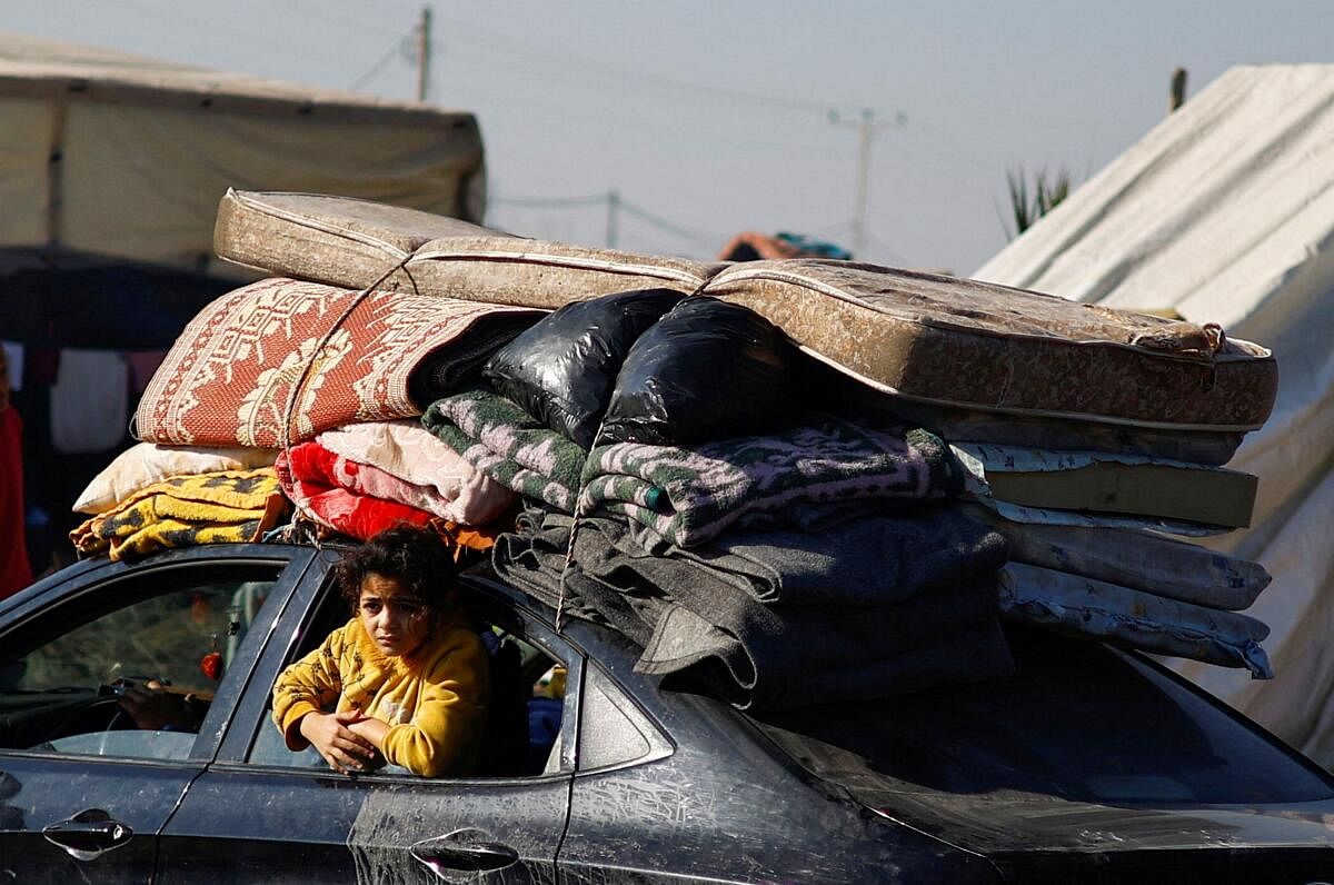 A person looks out from a car window as displaced Palestinians, who fled their houses due to Israeli strikes, shelter in a tent camp, amid the ongoing conflict between Israel and the Palestinian Islamist group Hamas, in Rafah in the southern Gaza Strip, December 26, 2023. 
