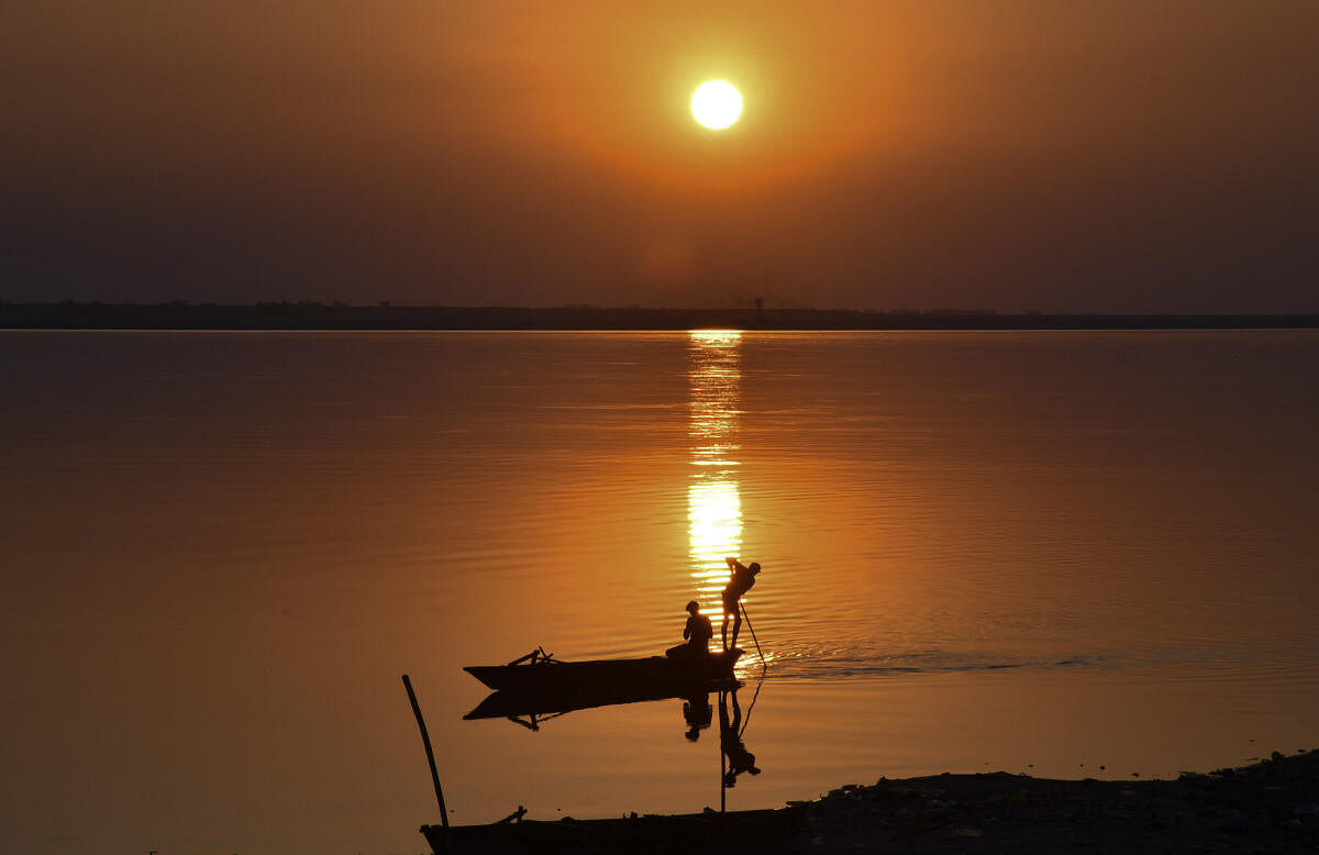 Fishermen silhouetted against the setting sun on the bank of the River Brahmaputra, in Tezpur.