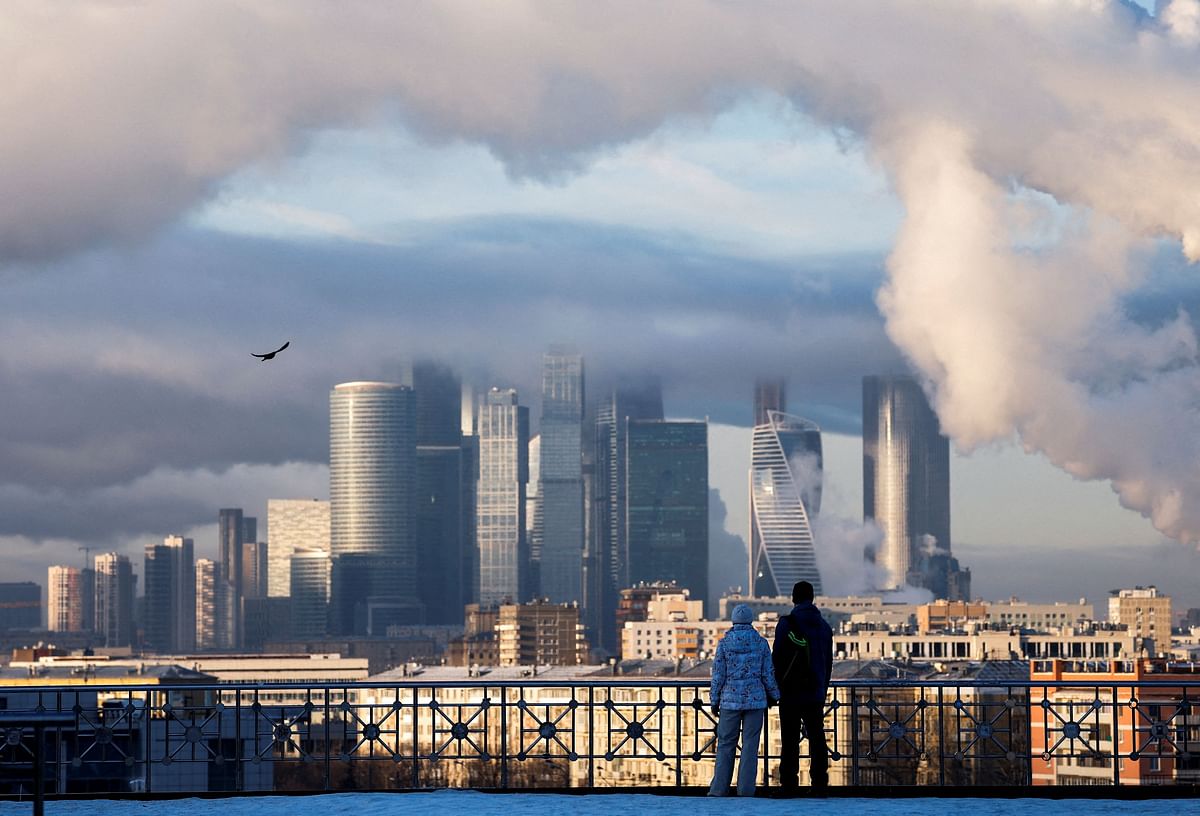 A couple watches as steam from chimneys of heating power plants rises over skyscrapers of Moscow International Business Centre, also known as Moskva-City on a frosty day in Moscow, Russia, January 3, 2024. REUTERS/Maxim Shemetov     TPX IMAGES OF THE DAY