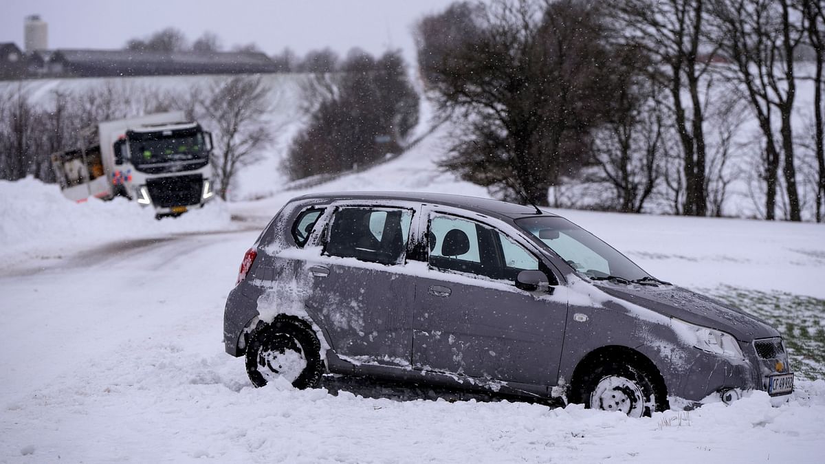Vehicles try to navigate their way through slippery roads, following heavy snowfall between OEdum and Mejlby in Denmark, January 4, 2024.  
