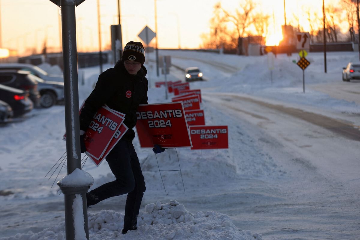 A staff member for Never Back Down removes campaign signs, following a Republican presidential candidate and Florida Governor Ron DeSantis campaign event, ahead of the caucus vote in Cedar Rapids.