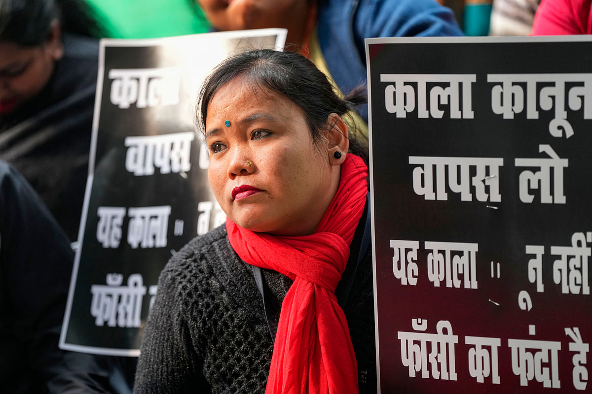 A woman driver holds a placard during the Transport Unions protest against the new penal law on hit-and-run cases, at Jantar Mantar, in New Delhi, Wednesday, Jan. 3, 2024.  