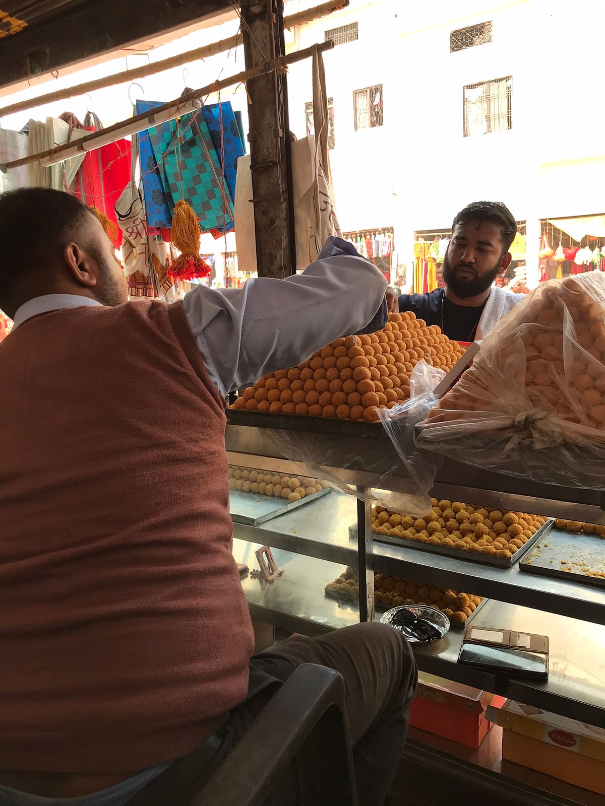 Sunil Gupta owns a laddoo shop in close proximity to the Hanuman Garhi temple. He suffered a significant loss of land during the acquisition process, and although the laddoos may receive a GI tag, the future of his business hangs in the balance if the rest of the shop is also acquired.