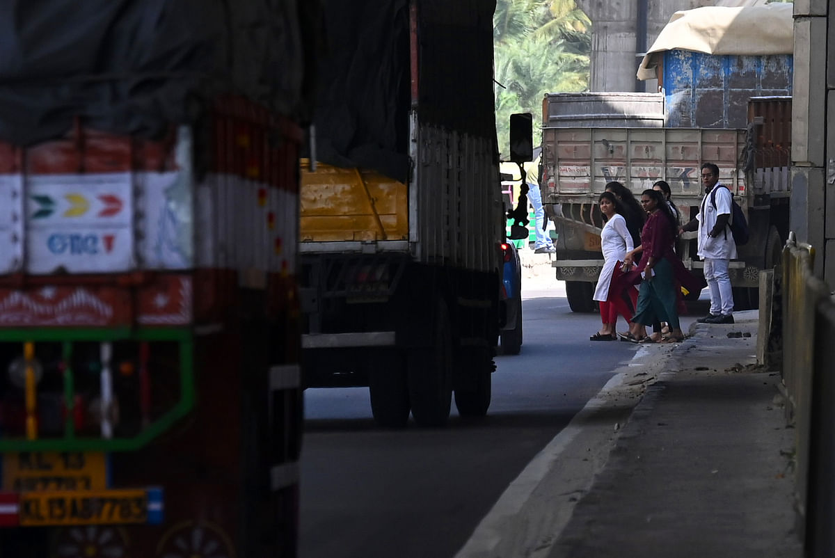 Due to a lack of foot-overbridge pedestrians risk crossing the busy Bengaluru-Mysuru highway near Challaghatta Metro Station in Bengaluru on Saturday December 30 2023. DH PHOTO/PUSHKAR V