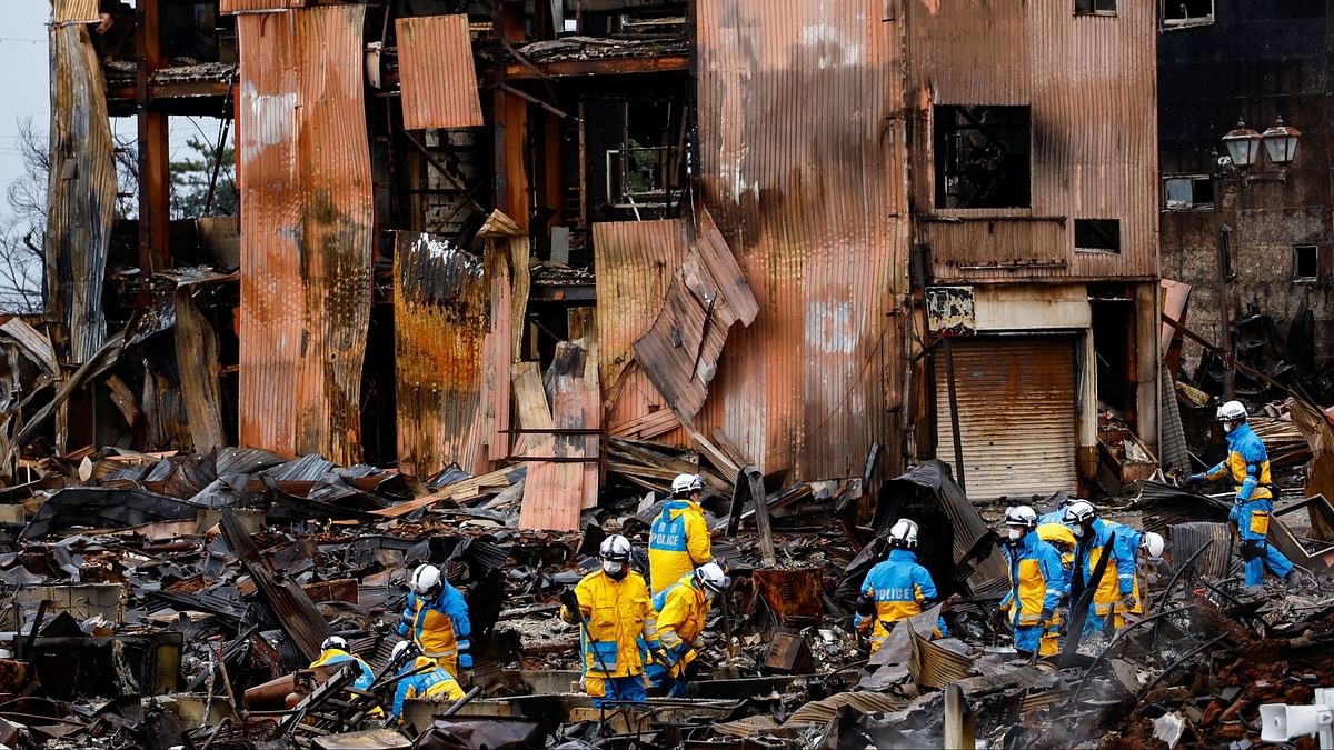Policemen search for victims in Asaichi-dori street, which burned down due to a fire following an earthquake in Wajima, Ishikawa Prefecture, Japan, January 7, 2024.