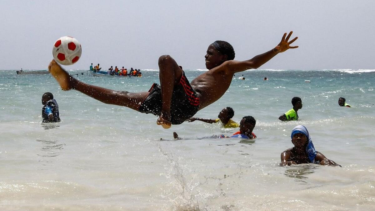 A boy plays football in the Indian Ocean waters at the Liido beach in Mogadishu.