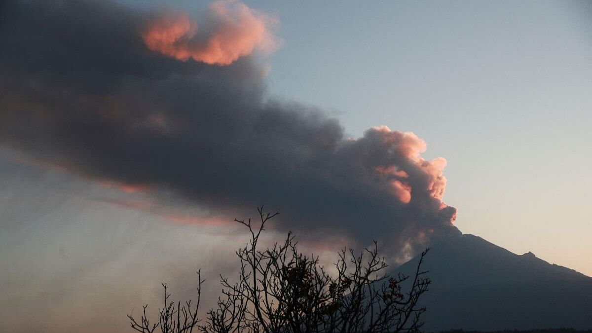 Popocatepetl volcano spews a column of ash and smoke, as seen from Santiago Xalitzintla.