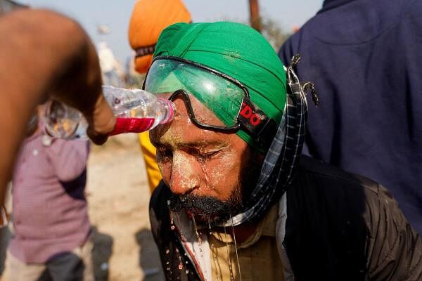 A protester who has applied multani mitti getting his face washed with water after coming in contact with tear gas.