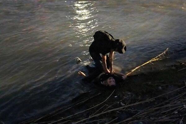 A man attempts to resuscitate a man from Mexico who is unconscious and lays on the shore of the Rio Grande River in Piedras Negras, Coahuila, Mexico, February 24, 2024. Moments earlier, the now unconscious man had led a group of migrants into the Rio Grande River with intentions to cross into Eagle Pass, Texas, US. 