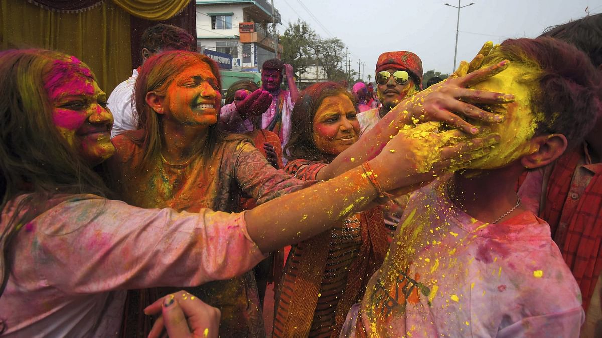 People play with colours during Holi celebrations, in Nagaon.