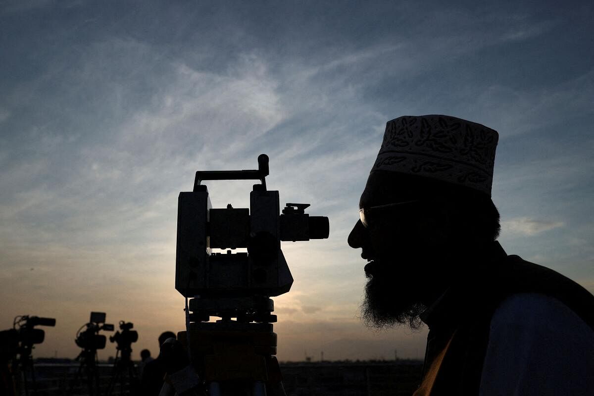A member of Pakistan's moon sighting committee is silhouetted as he uses theodolite to look for the new moon as Muslims attend an evening prayer session called 'Tarawih' to mark the holy fasting month of Ramadan in Peshawar, Pakistan March 11, 2024.