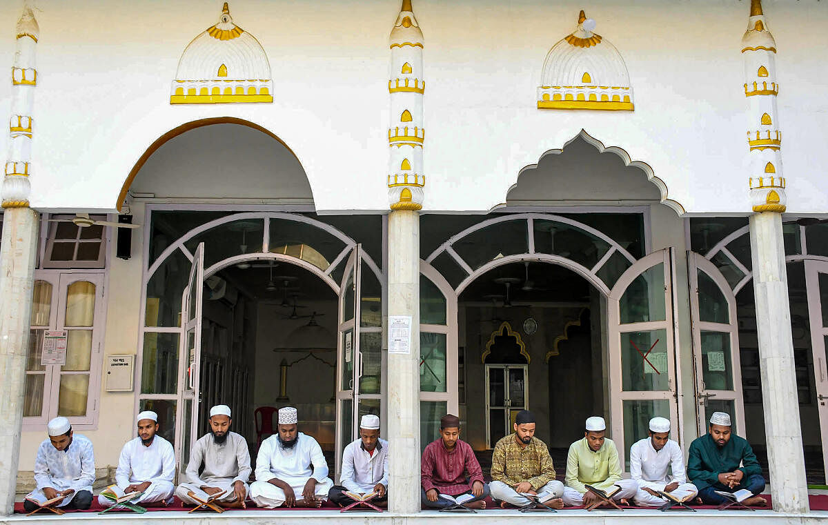 Muslim men recite a religious text at a madrasa during the holy month of Ramzan, in Guwahati