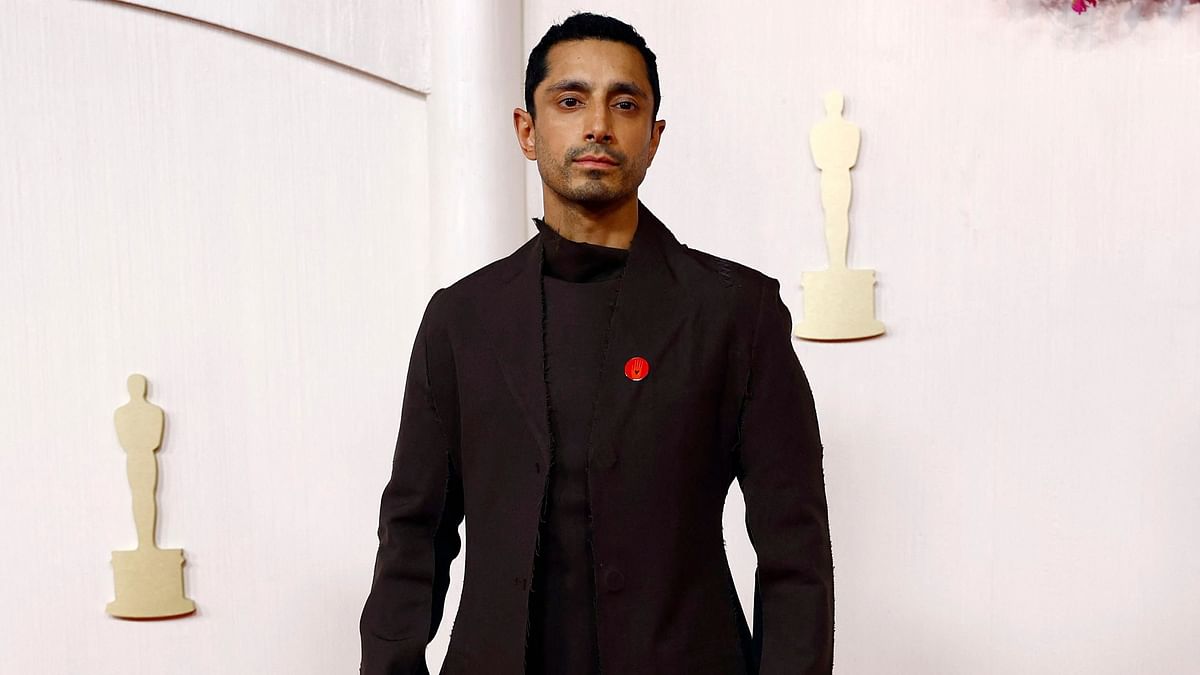 Riz Ahmed walked the red carpet with pins calling to protect trans children attached to the lapel of his black long coat.