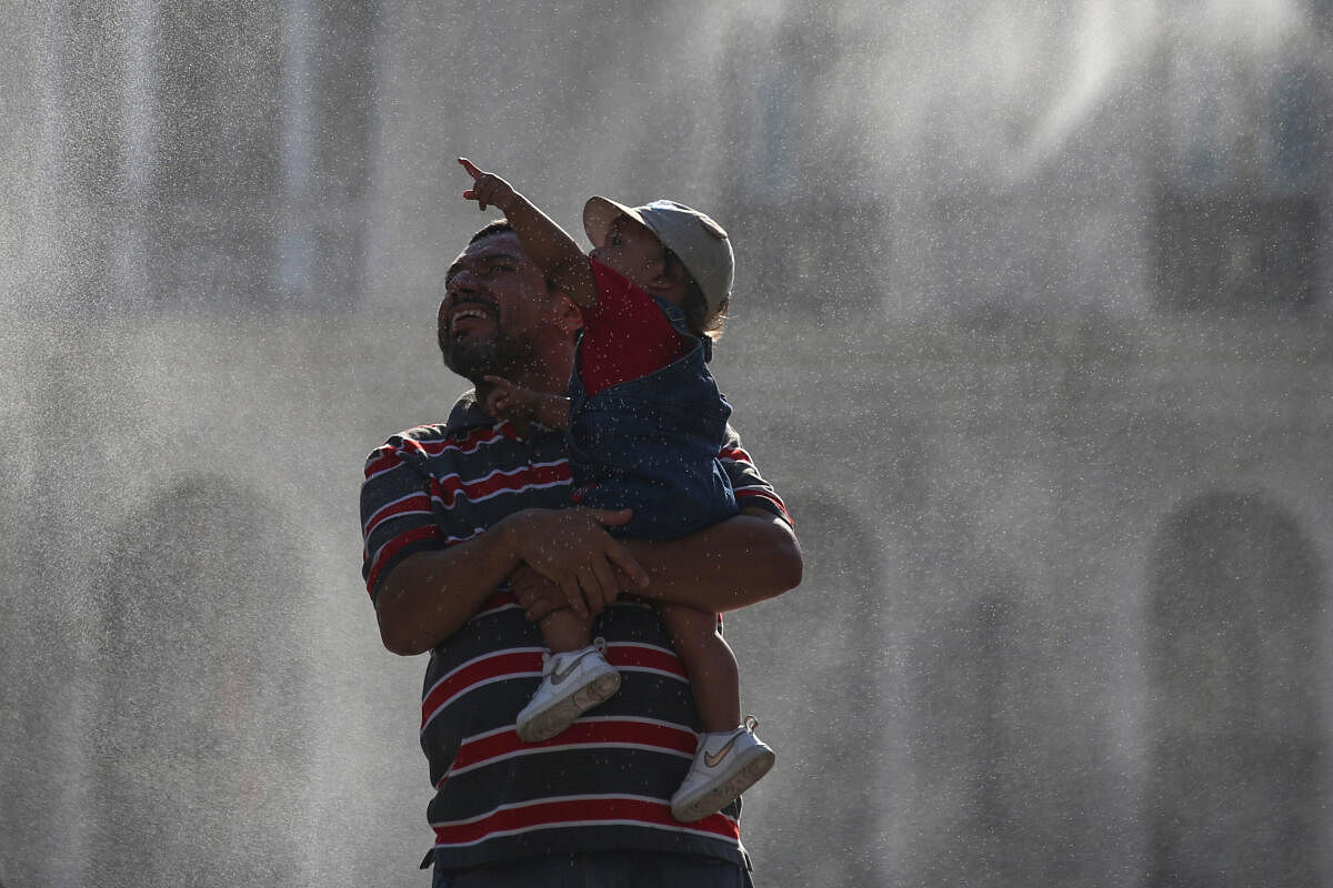 A child reacts as water is sprayed by a system to alleviate the high temperatures caused by a heat wave, at the Gerardo Barrios square, in San Salvador, El Salvador.