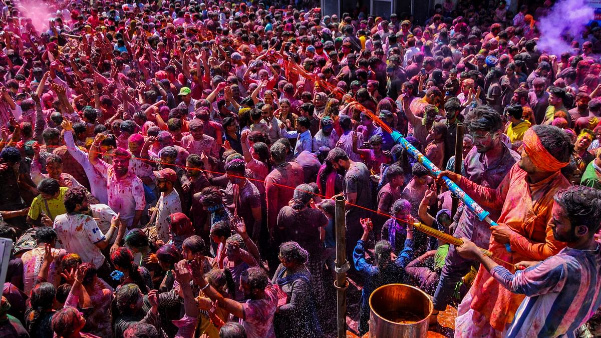 People play with colour and spray water on each other during Holi festival celebrations, at Durgiana Temple in Amritsar.