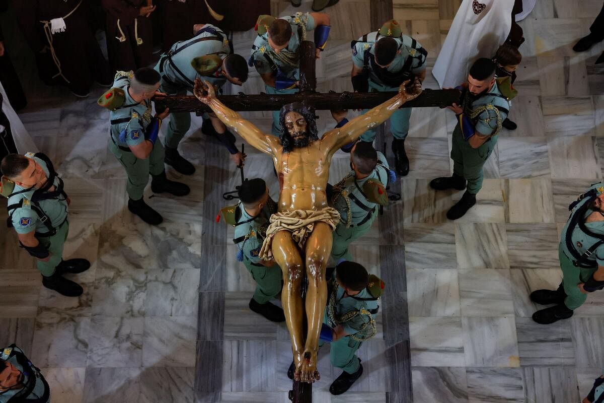 Spanish legionnaires carry a statue of Christ, known as the 'Christ of the Good Death', as they take part in a penitence act inside a church.